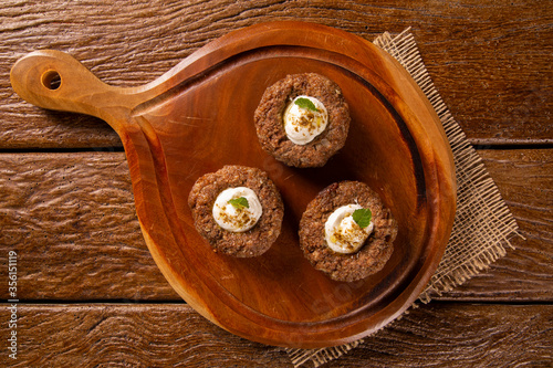 kibe stuffed with dry curd on wood background.
