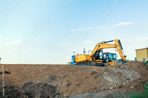 Excavator on the construction of a road embankment Fototapeta