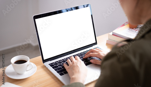 Back side of Asian woman working from home with a blank screen and close-up view.
