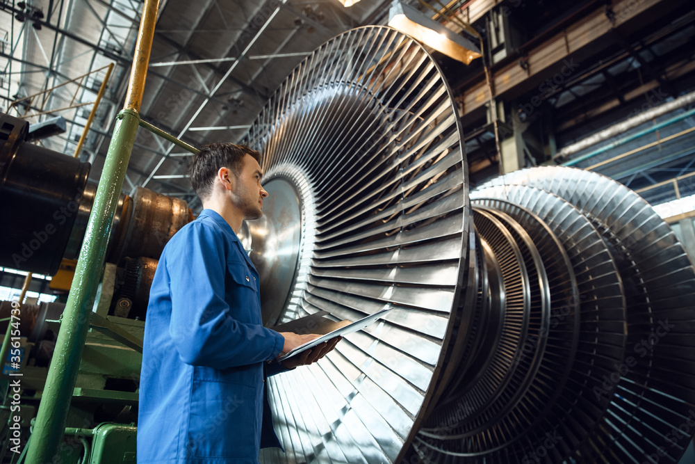 Engineer checks turbine impeller vanes, factory - obrazy, fototapety, plakaty 