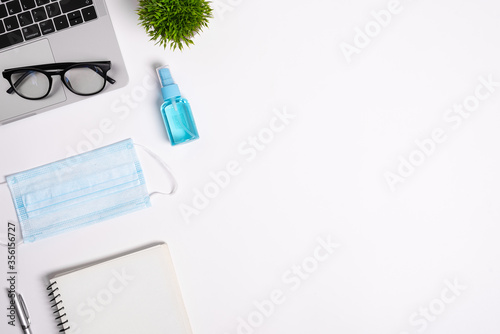 The equipment to protect COVID-19, blue mask and hand cleaner gel for preparing to work from home Isolated on white background concept.