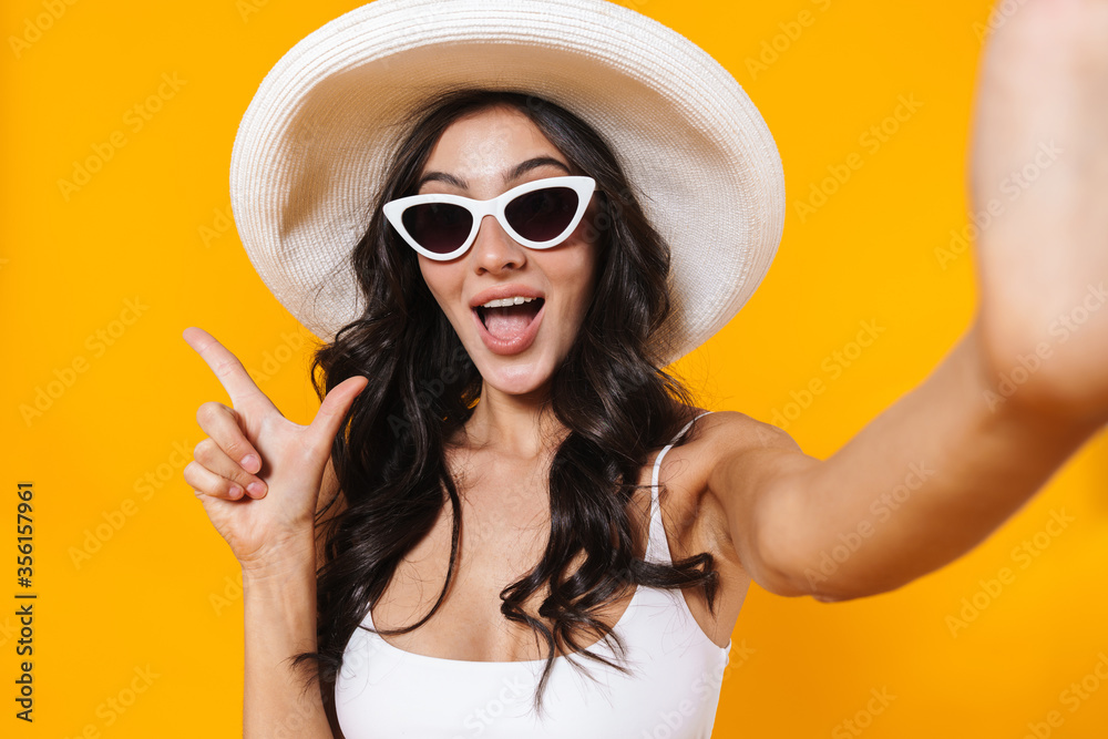 Image of excited woman pointing finger aside while taking selfie Image of excited woman pointing finger aside while taking selfie