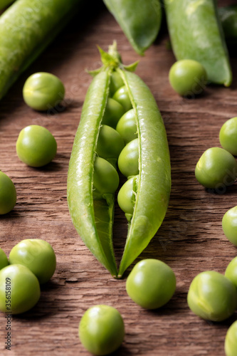Close up of freshly picked peas on a wooden table.