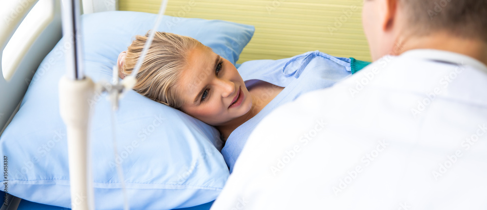 Doctor reassuring her female patient on bed at hospital room Doctor reassuring her female patient on bed at hospital room