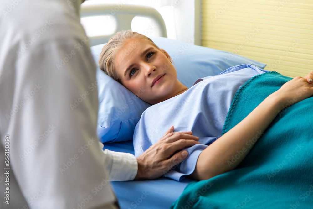 Doctor reassuring her female patient on bed at hospital room Doctor reassuring her female patient on bed at hospital room