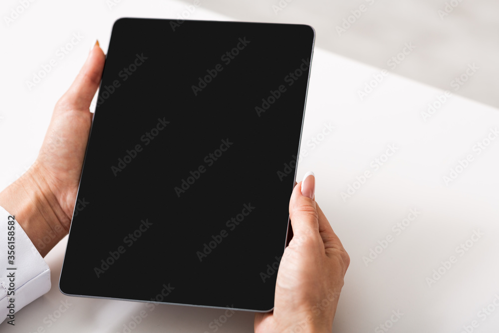 Gadgets for working at home and in office. Woman holds tablet with blank screen Gadgets for working at home and in office. Woman holds tablet with blank screen