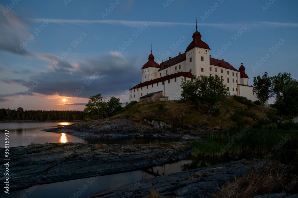 Long exposure of Läckö castle in the evening with full moon rising over lake Vänern, Lidköping, Sweden