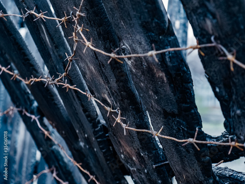 Burnt fence with barbed wire. The consequences of not careful and thoughtless handling of fire. photo