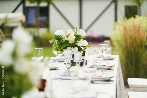 Table with candles and a bouquet of white flowers on nature before a birthday celebration