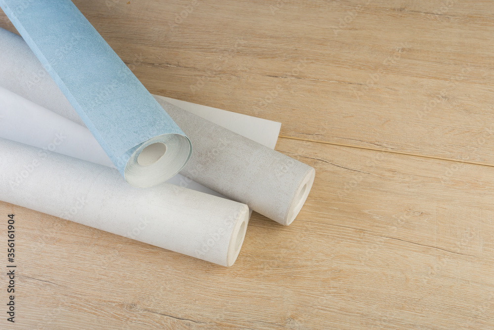 Obraz premium rolls of multi-colored paper wallpaper on a wooden table