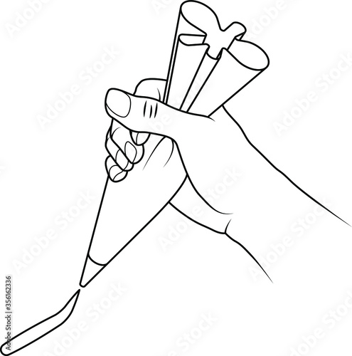 A hand holding a piping bag with a line of shaped icing mixture.