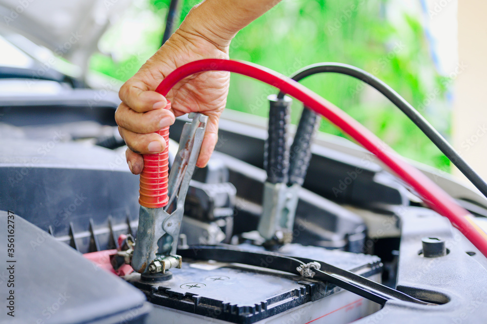 The booster cables and discharged battery, Charging car battery with electricity trough jumper cables