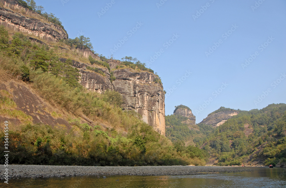 Wuyishan mountains in Fujian Province, China. View of the scenic Wuyi mountains from a raft on the Nine Bends River or Nine Twists Stream. Wuyi mountains are a UNESCO site in China.