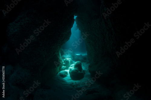 Diffused sunlight descends into a dark, submerged cavern at the southern tip of Yap. Underwater caves and crevices offer shadowed habitats for creatures that do not like light.