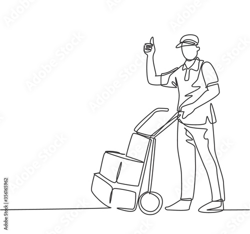 One line drawing of young delivery man gives thumbs up gesture while carrying carton box package with trolley to customer. Delivery service concept. Continuous line draw design vector illustration
