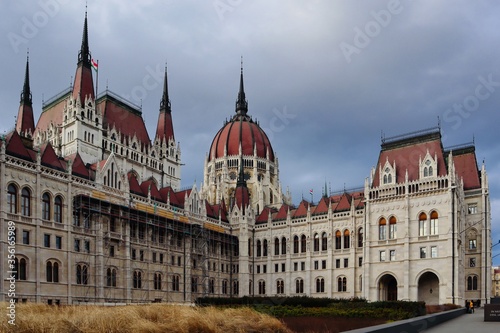 Hungarian Parliament Building on a Cloudy Day. Red Roofed Architecture in a City.