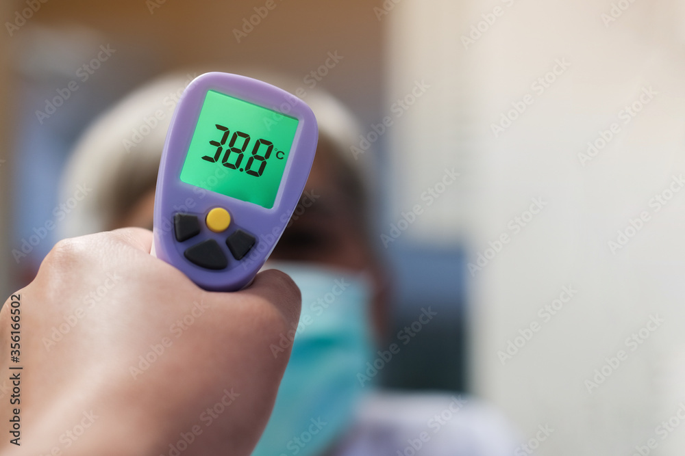 Medical staff using a thermometer gun machine check body temperature