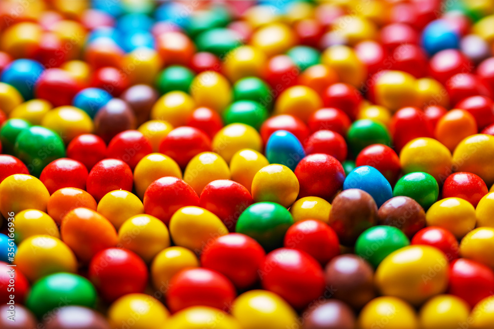 Image of colored round sweets. Background of small multicolored dragees. Closeup. Side vew. Image of colored round sweets. Background of small multicolored dragees. Closeup. Side vew.