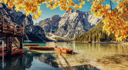 Magnificent Autumn Landscape. Amazing Mountain Lake Braies in the Dolomates. Scenic image of Fairytale lake Lago di Braies with Colorful Leafes. Awesome alpine highlands in sunny day under sunlit