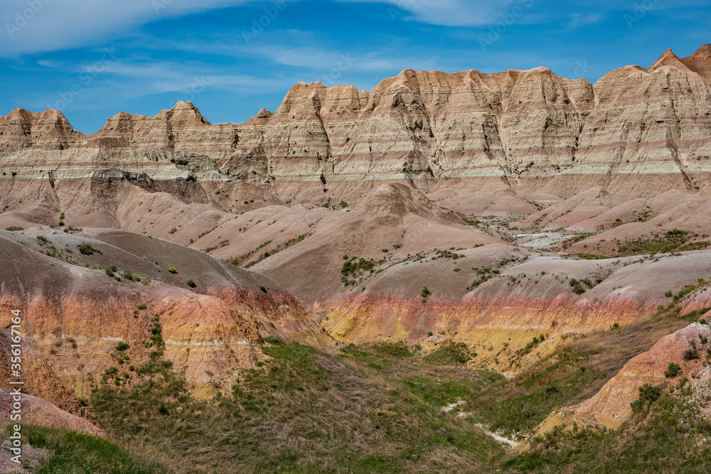 Reds, yellows, oranges and browns color the arid rocks, ridges and cliffs in the rugged Badlands of South Dakota.