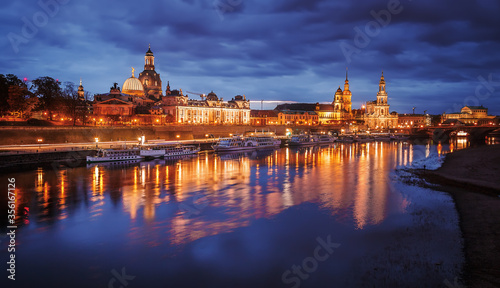 Fantastic colorful sunset in Dresden with dramatic sky, over the Elbe river. Old Town glowing in lighten reflected in calm water. Picturesque unusual scene. Creative image. Famouse Dresden buildings