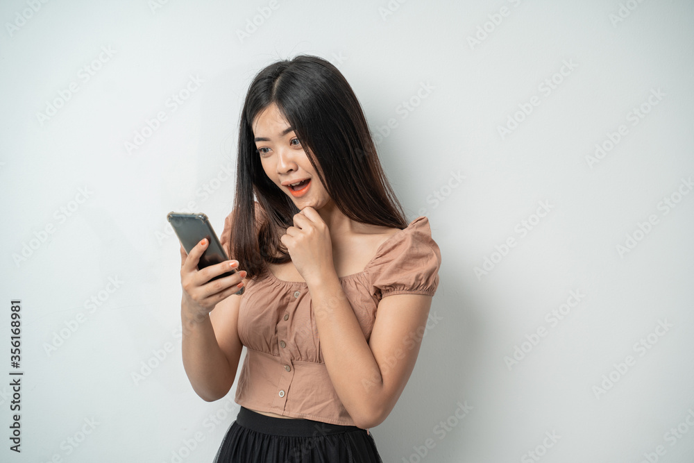 Beautiful girls are interested in looking at the screen of a smart phone with an isolated background Beautiful girls are interested in looking at the screen of a smart phone with an isolated background