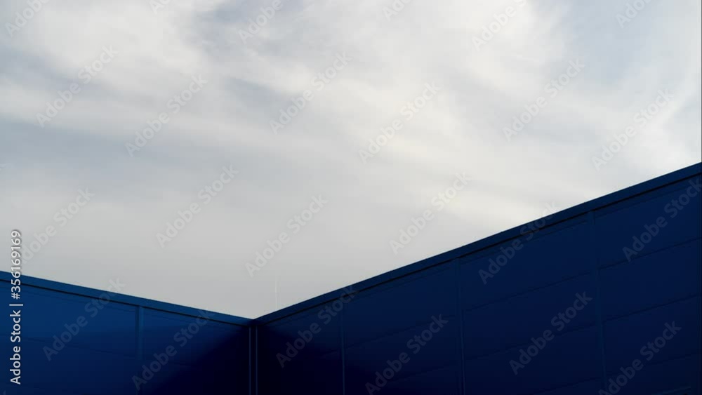 Clouds over the sky are floating in a blue modern building. The building is new without windows. Time lapse Clouds over the sky are floating in a blue modern building. The building is new without windows. Time lapse