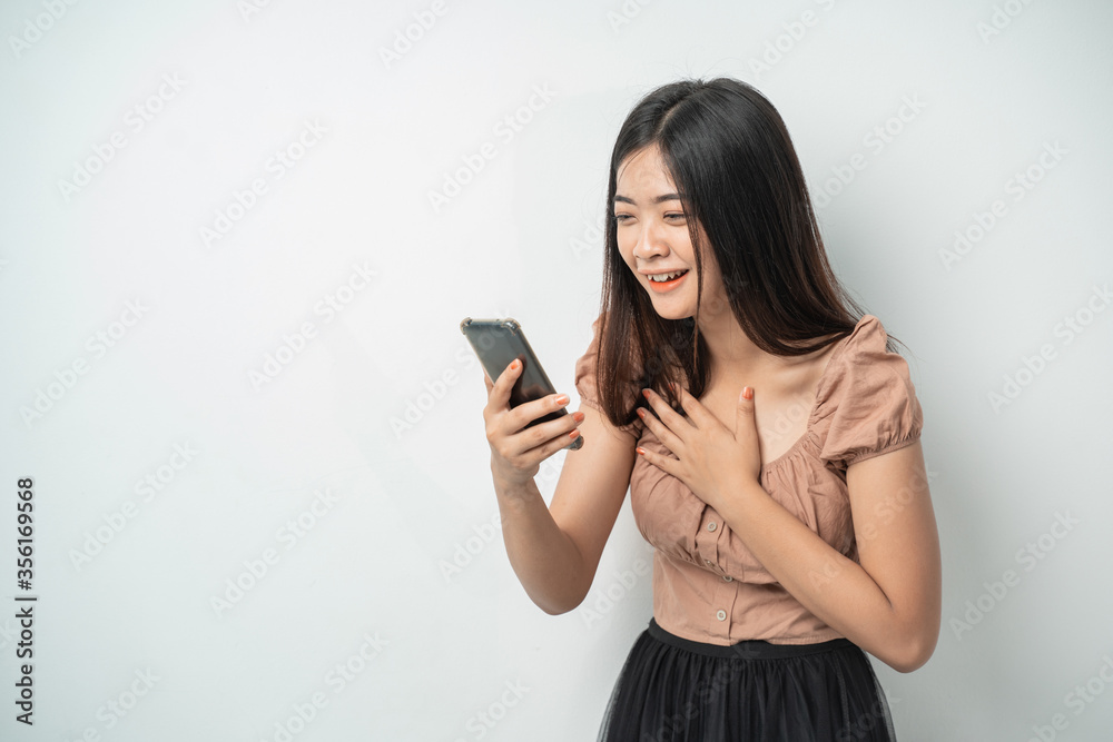 Beautiful girls with surprise expressions when using smart phone gadgets with isolated backgrounds Beautiful girls with surprise expressions when using smart phone gadgets with isolated backgrounds