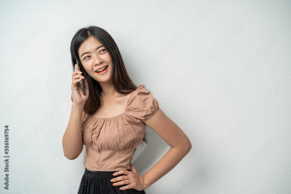 pretty girl with long hair smile when calling using smart phone with an isolated background pretty girl with long hair smile when calling using smart phone with an isolated background