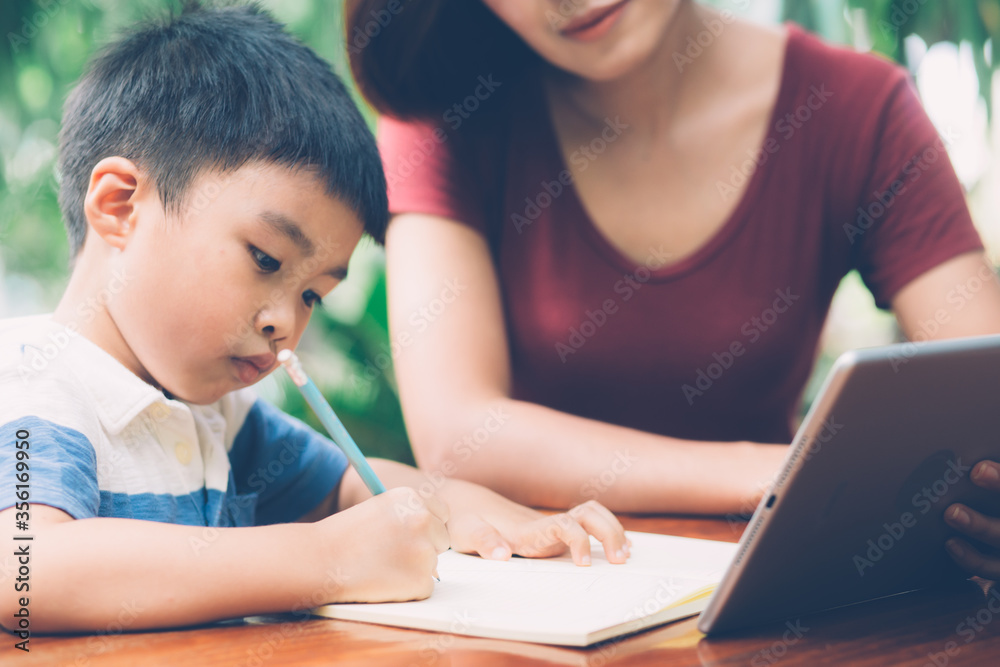 Son using digital tablet computer for study and learn to internet online with mother together, education from home, family recreation, mom teach boy and homework with technology, lifestyle concept. Son using digital tablet computer for study and learn to internet online with mother together, education from home, family recreation, mom teach boy and homework with technology, lifestyle concept.
