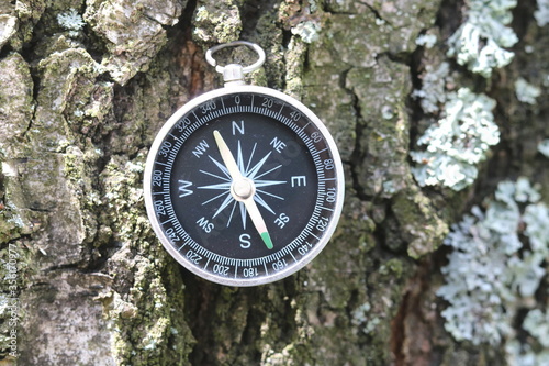 round compass on natural background as symbol of tourism, travel and outdoor activities