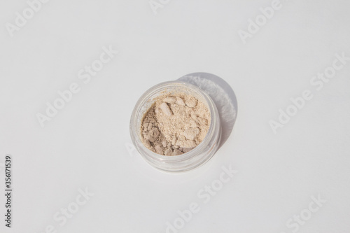 Blusher, eyeshadow and transparent face powder on white background with copy space, close-up.