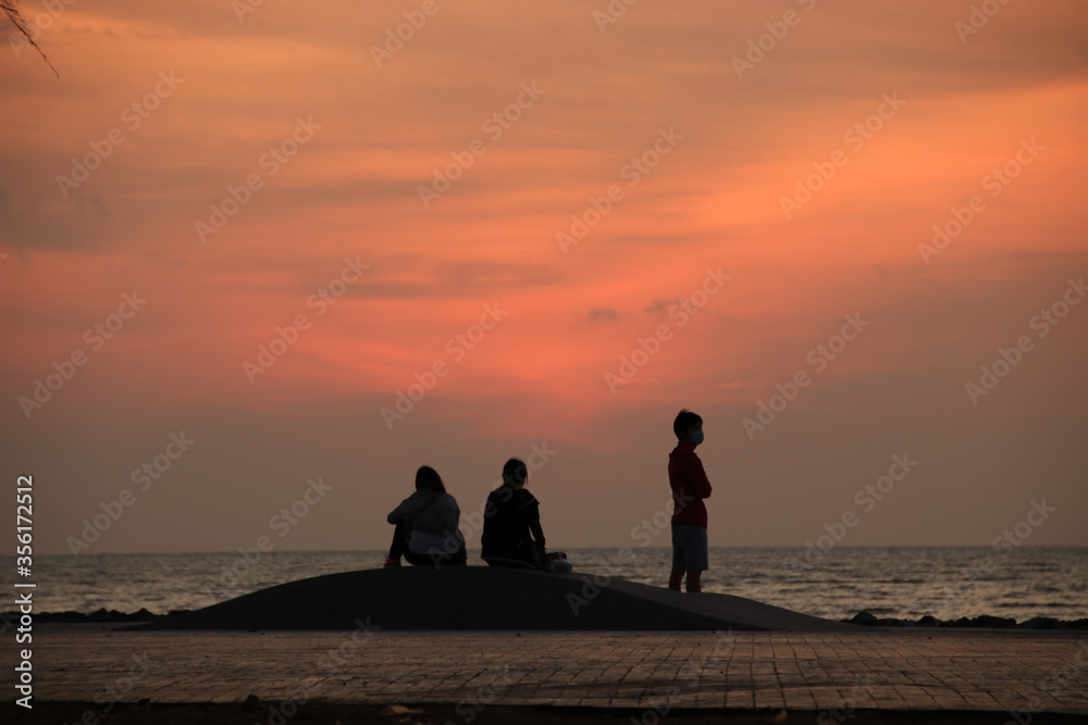 silhouette of a people on the beach at sunrise