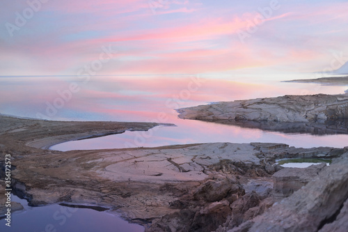 Sunset light sky clouds reflection in quiet sea no waves