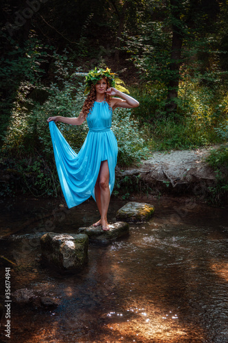 a beautiful young woman celebrates in the woods the solstice day