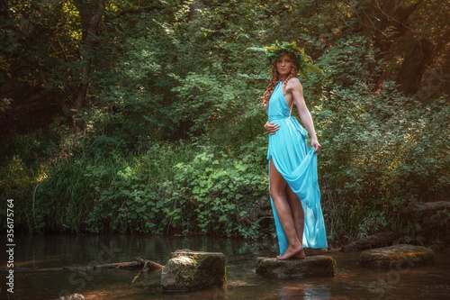 a beautiful young woman celebrates in the woods the solstice day