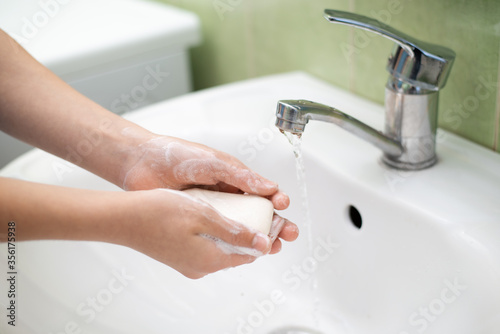 Concept of personal hygiene. Washing hands under the tap