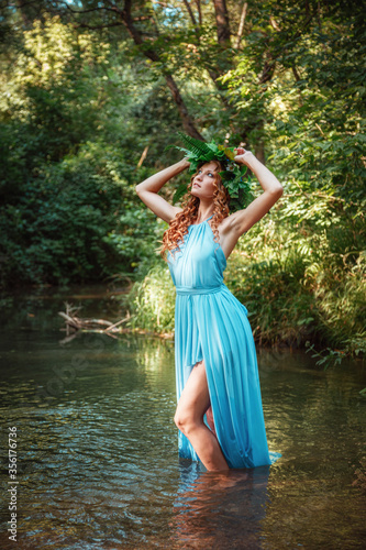 a beautiful young woman celebrates in the woods the solstice day