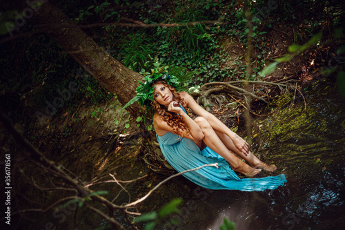 Fototapeta Naklejka Na Ścianę i Meble -  a beautiful young woman celebrates in the woods the solstice day