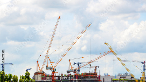 The industrial building crane behind the blue sky and white clouds