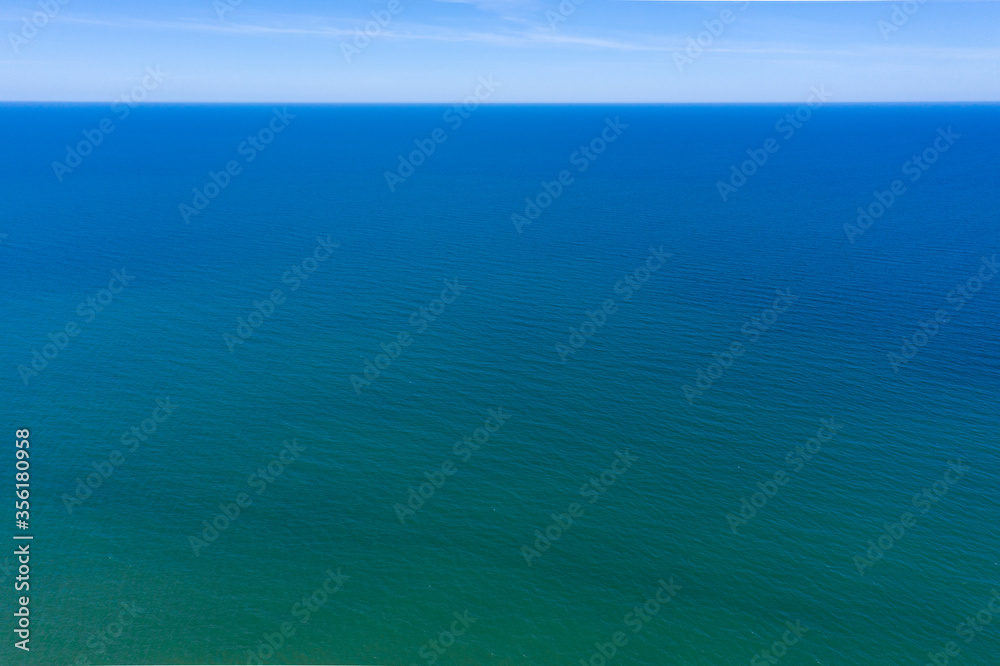 View from the top to the endless blue distance of the Baltic Sea. On the horizon, the sea flows smoothly into the sky.