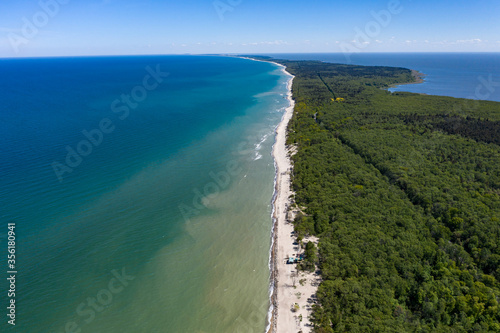 Beautiful view from above of the Curonian spit national Park. On the right - the blue Baltic sea, on the left-the Curonian lagoon. A sandy strip of beach stretches away into the distance.