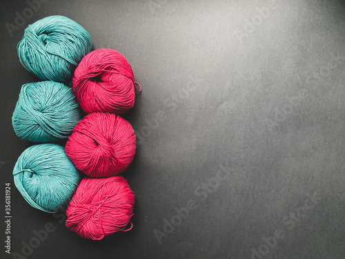 Turquoise and bright pink yarn for knitting on a black background. Needlework, crocheting, Hobbies.
