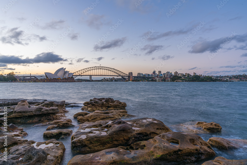 Naklejka premium Sydney harbor skyline at sunset with Sydney harbor bridge, NSW, Australia