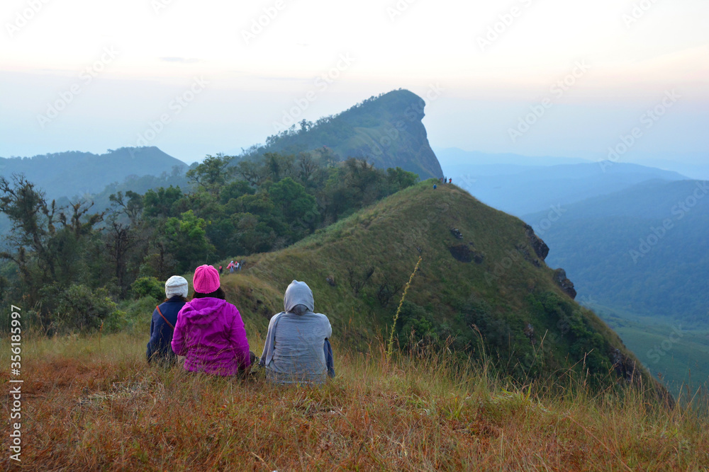 Fototapeta premium the tourist look around mountains brown grass and cloudy sky landscape