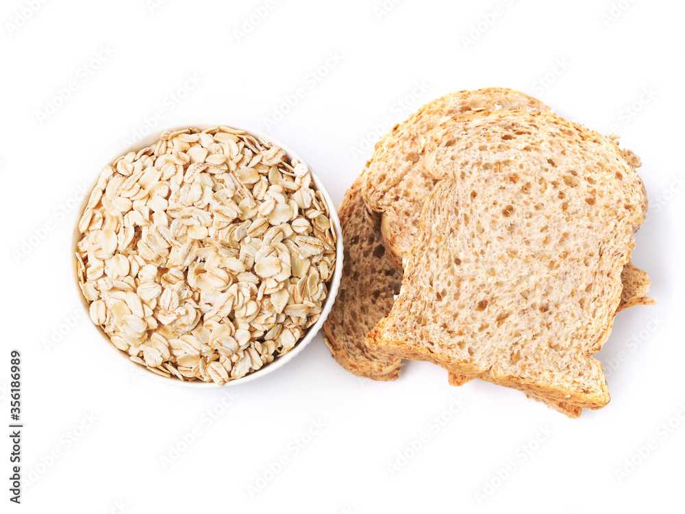 Top view of rolled oat flakes whole grain in bowl and whole wheat bread isolated on white background. Top view of rolled oat flakes whole grain in bowl and whole wheat bread isolated on white background.