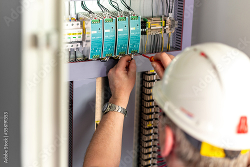 Electromechanic in helmet fixing electrical panel photo