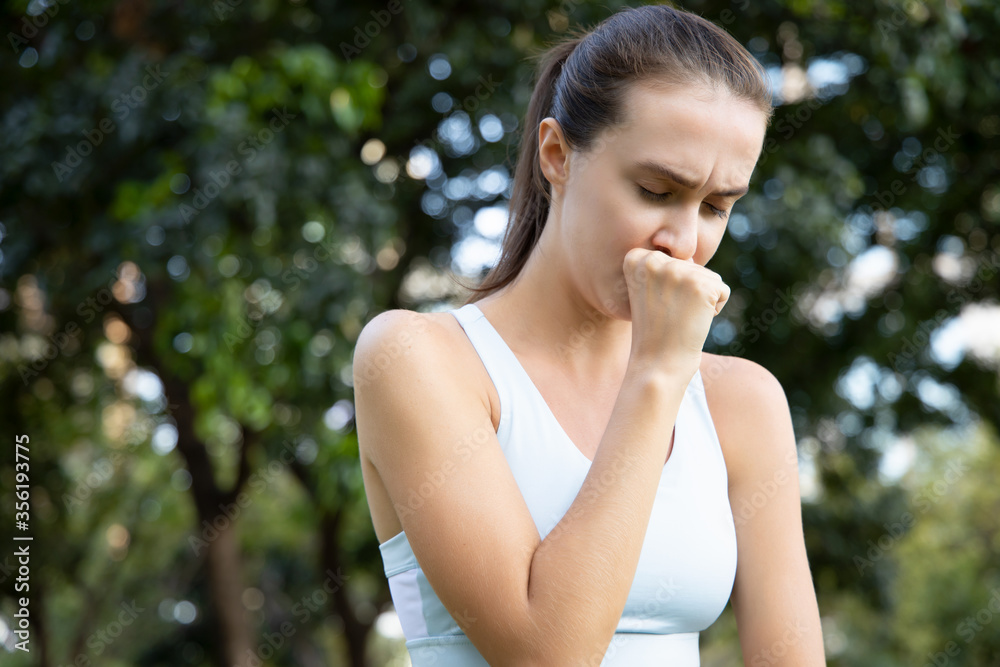 sick woman coughing with sore throat; sick woman with cough symptom, sore throat, cold, flu, contagious disease, virus outbreak, coronavirus, COVID 19, health care concept; young adult woman model sick woman coughing with sore throat; sick woman with cough symptom, sore throat, cold, flu, contagious disease, virus outbreak, coronavirus, COVID 19, health care concept; young adult woman model