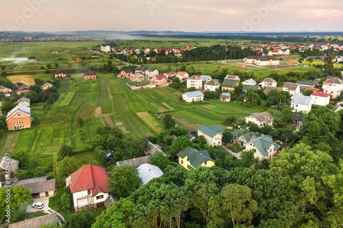Aerial landscape of small town or village with rows of residential homes and green trees. photo