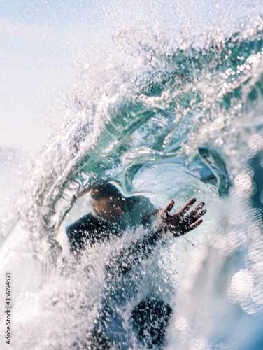 surfer caught inside the lip of a wave photo